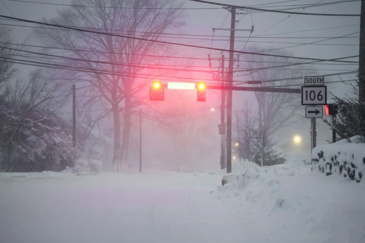 Snowstorm over a road with a traffic light and power lines